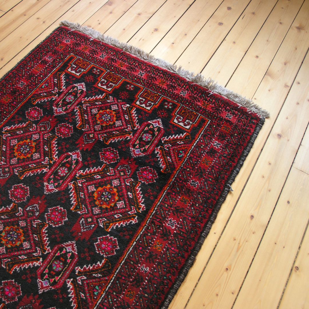 Red oriental rug on a wood floor. 