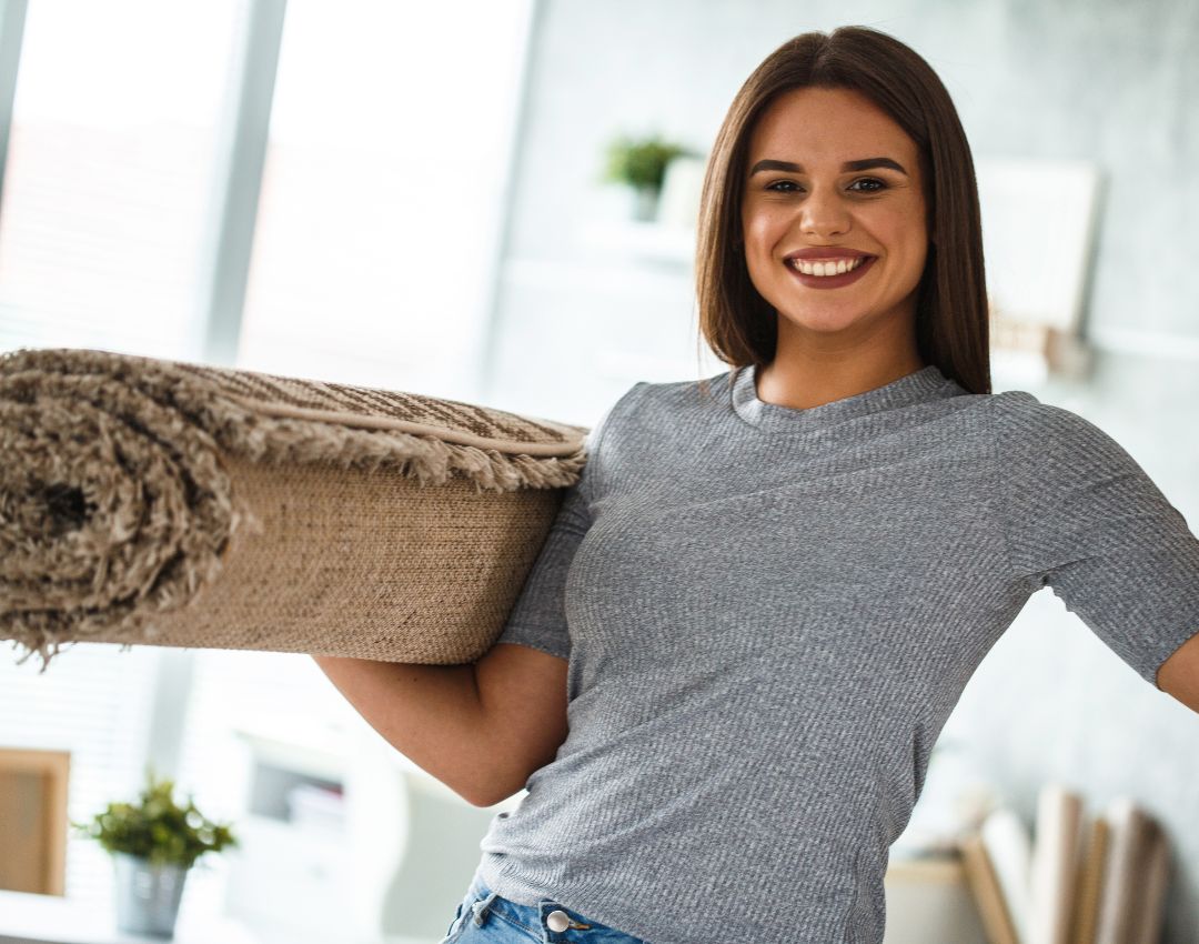 A happy customer holding a clean rug
